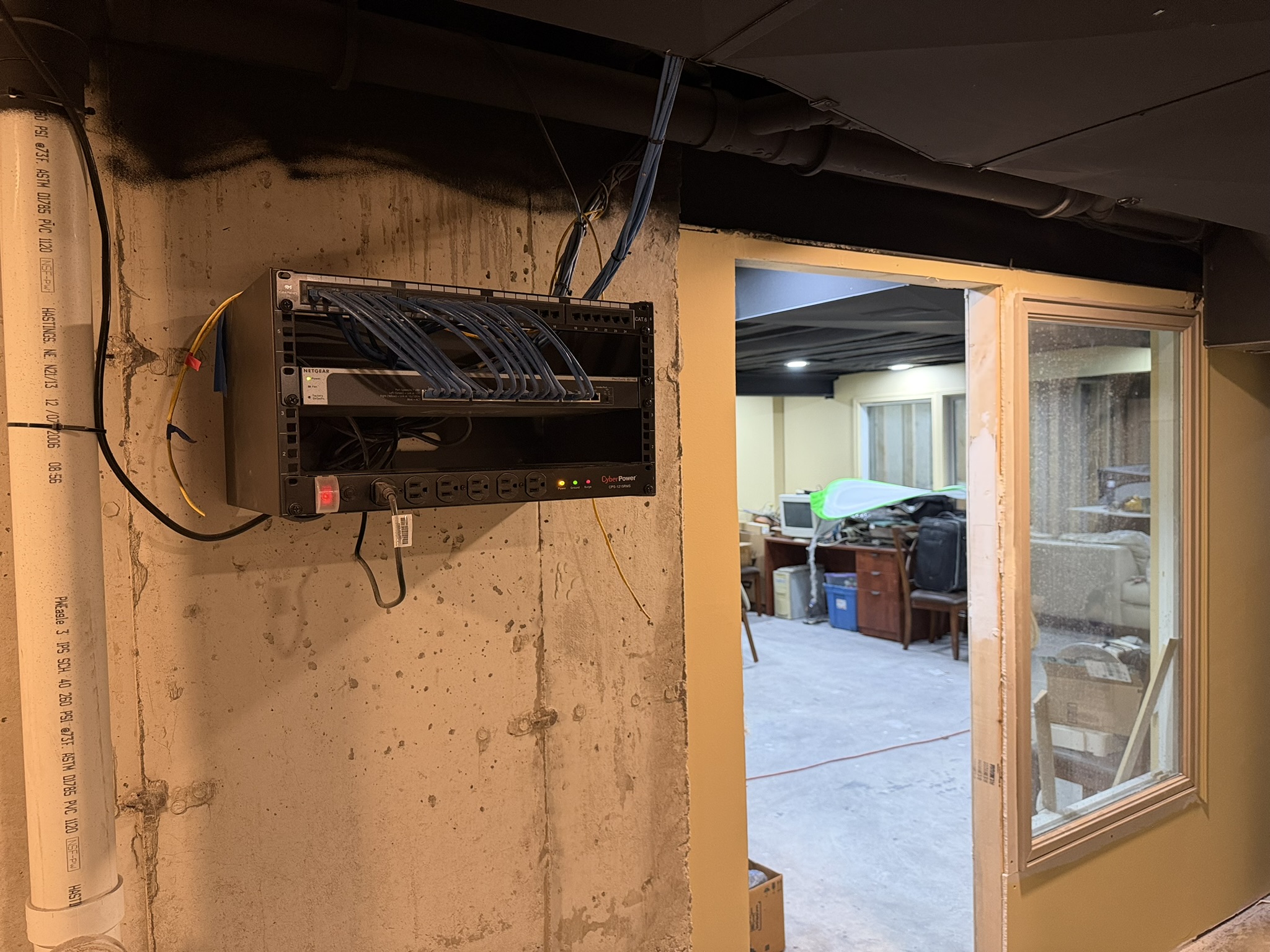 Home network rack with patch panel, switch and blue Cat 6 cables